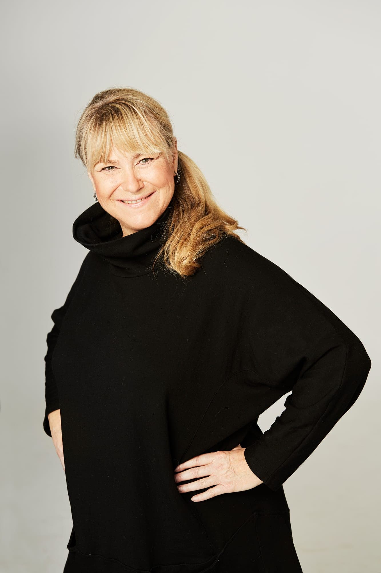 Christine Feldthaus i sort rullekravebluse med hånden i siden