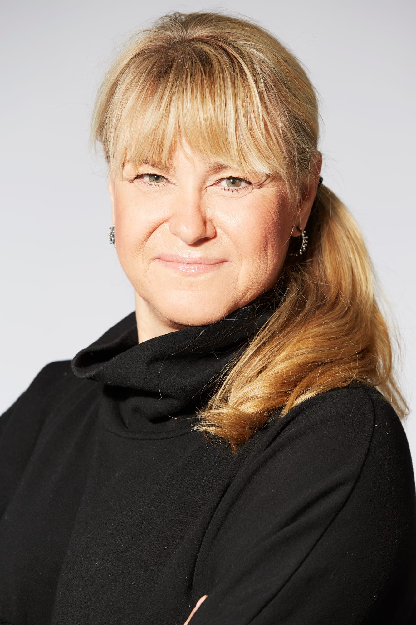 Portræt af Christine Feldthaus i sort rullekravebluse mod lys baggrund