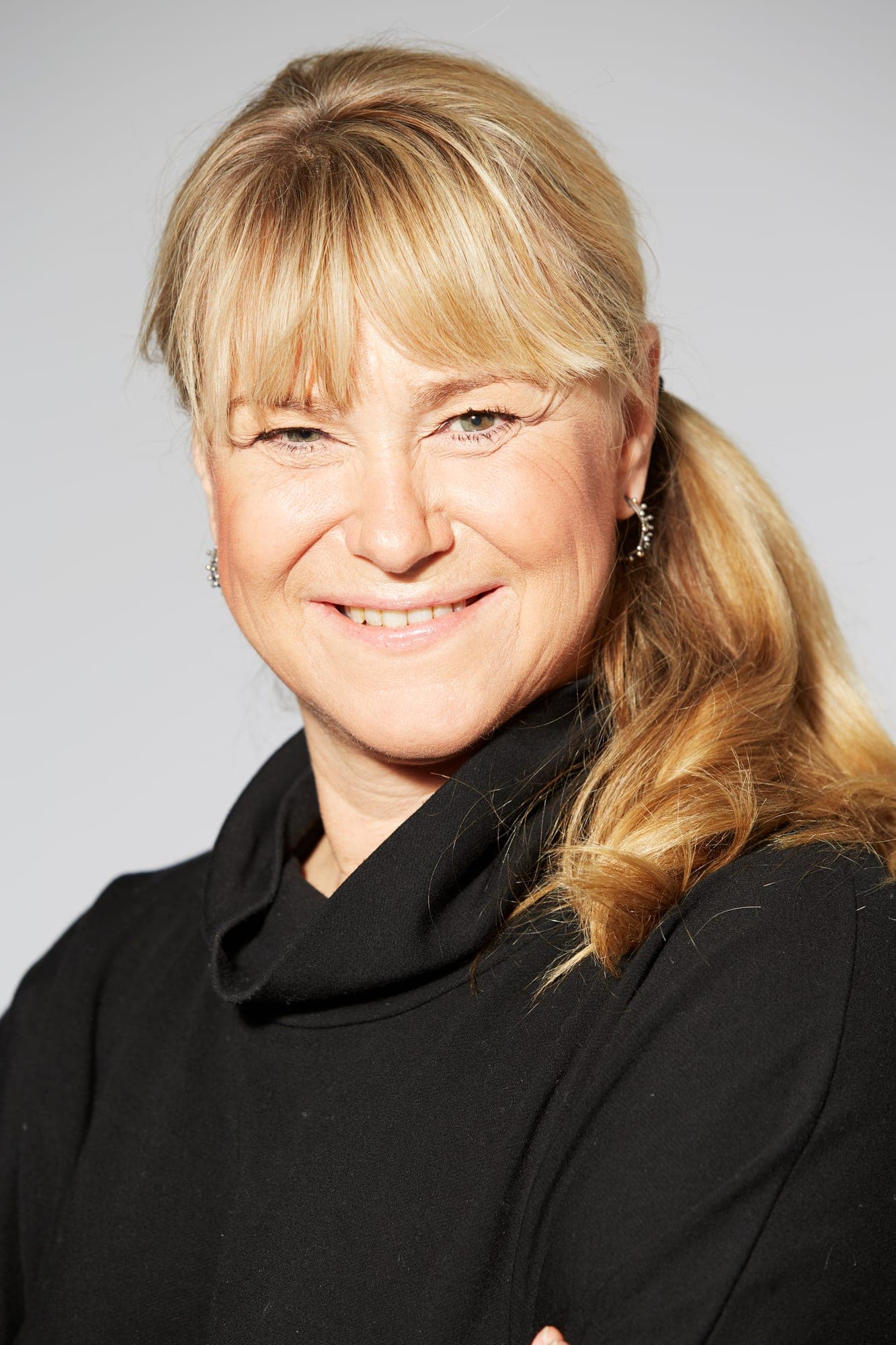 Smilende portræt af Christine Feldthaus i sort rullekravebluse